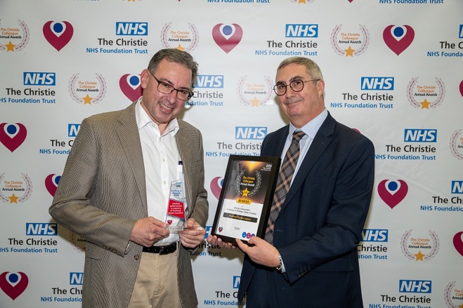 A photo of Professor Gordon Jayson receiving his Christie Colleague Award from Christie Chief Executive Roger Spencer.