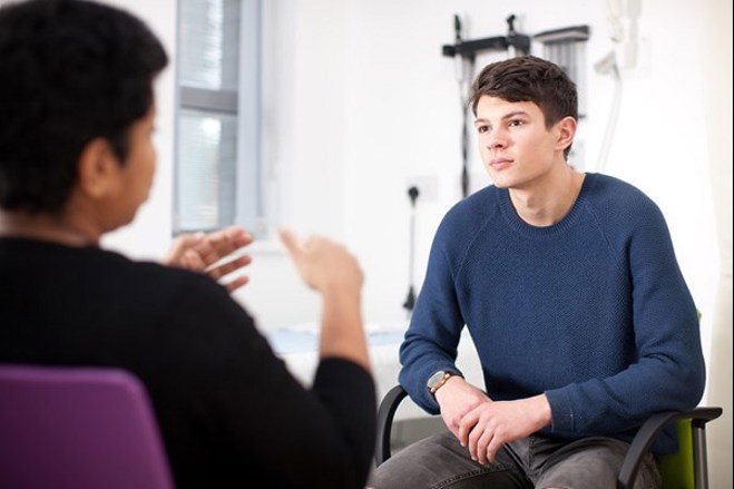 A photo of a young cancer patient talking to a doctor