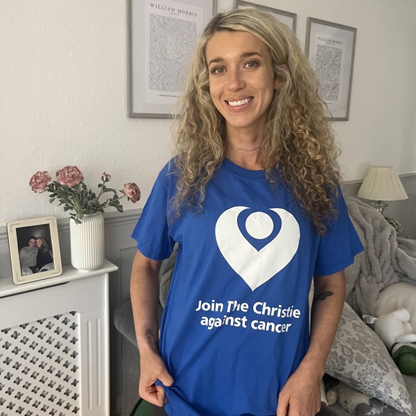 A photo of Christie patient and fundraiser Beth Gallagher wearing a Christie Charity t-shirt that reads "Join The Christie against cancer".