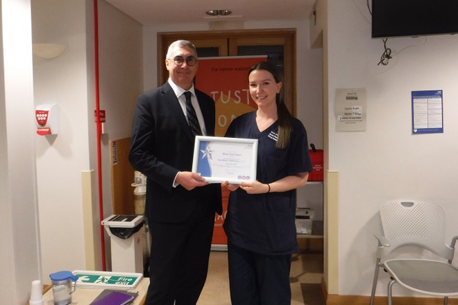 A photo of Molly Darrington, pre-op assessment nurse practitioner, with Christie Chief Executive Roger Spencer as she is presented with her award as the winner of The Christie’s You Made a Difference Award for November 2024.