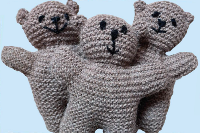A photo of 3 grey crocheted teddy bears.