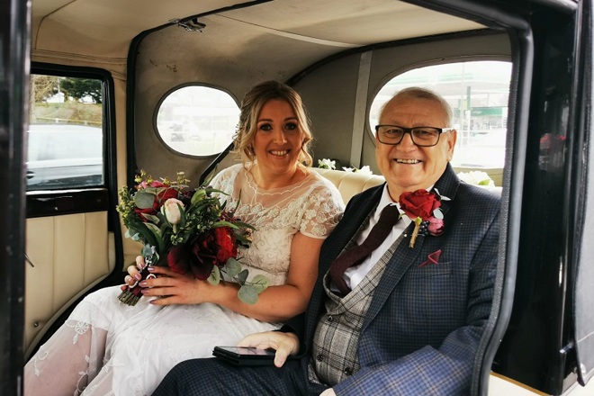 A photo of Christie patient Terry Berry and his daughter Carla in a wedding car for Carla's wedding.