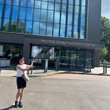 A photo of Christie patient Maya Tohid standing outside the proton beam therapy centre at The Christie.