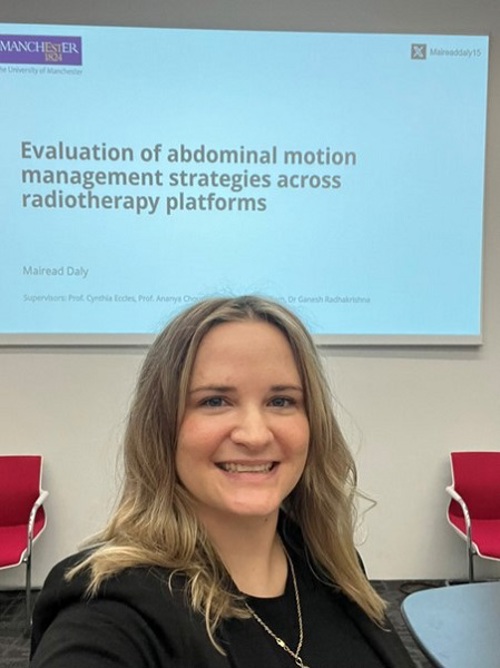 A photo of Christie MR-Linac staff member Mairead Daly presenting her work at the annual MR-Linac Consortium meeting. The presentation slide reads 'Evaluation of abdominal motion management strategies across radiotherapy platforms'.