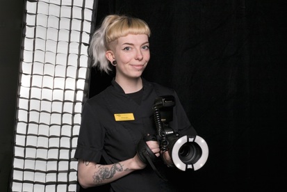 A photo of Georgia Woodcock, a medical photographer at The Christie holding a camera.