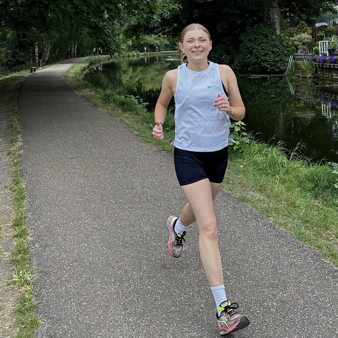 A photo of Christie fundraiser Emily Hayes running next to a canal.