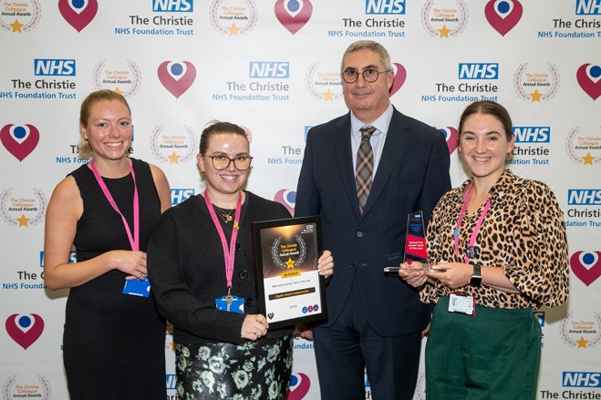 A photo of the digital clinical implementers team at The Christie receiving their Christie Colleague Award from Christie Chief Executive Roger Spencer.