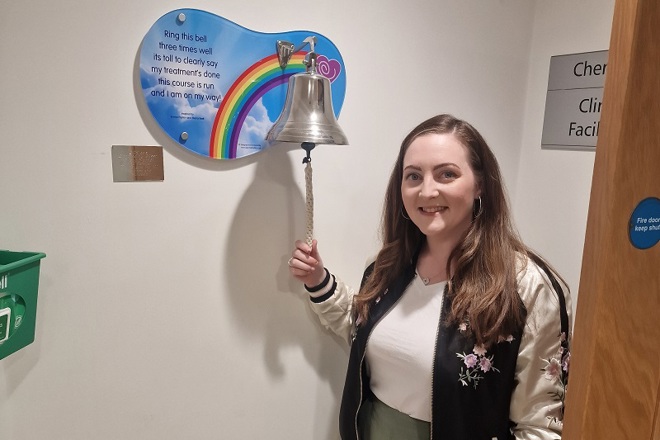 A photo of Christie patient Zara McCormick ringing the end-of-treatment bell.