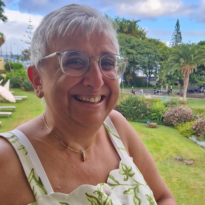 A photo of Christie patient Liz Bates sat in a garden.