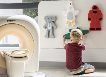 A photo of a young patient playing with the toy scanner at The Christie.